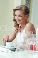 Cheerful attractive woman posing at table
