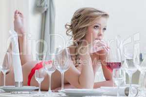 Thoughtful curvy woman lies with glass of wine