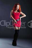 Hot red-haired woman posing in studio