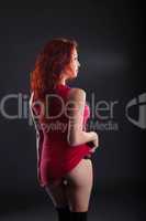 Sexy red-haired woman posing back to camera