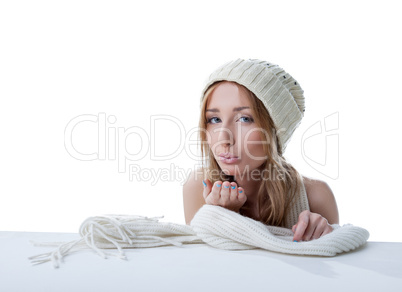 Lovely girl in knitted hat sending air kiss