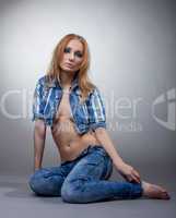 Thoughtful woman posing topless in denim suit