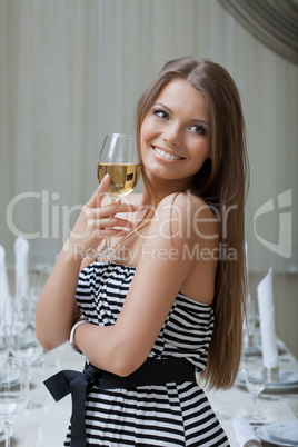 Charming smiling girl posing with glass of wine