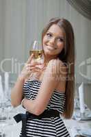Charming smiling girl posing with glass of wine