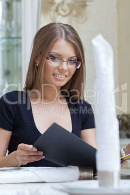 Cute smiling girl makes order in restaurant