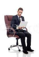 Handsome businessman sitting in chair with laptop