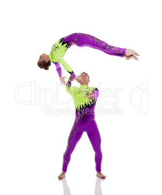 Flexible gymnasts performing tricks in studio