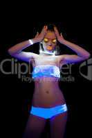 Energetic girl with UV make-up posing at disco