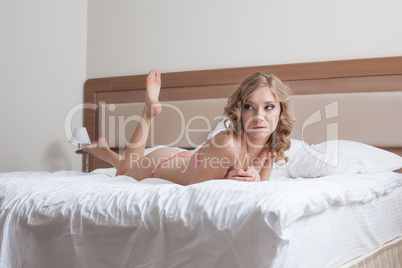 Pretty young model lying on hotel's bed