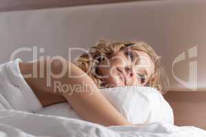 Portrait of lovely dreamy girl lying in bed