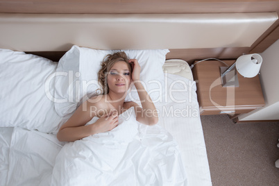 Image of smiling awakened girl lying in bed