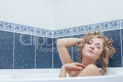 Portrait of languid young woman lying in bath