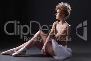 Charming young ballerina posing topless in studio