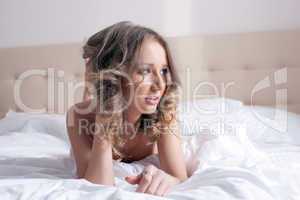 Portrait of sexy curly model posing in bedroom