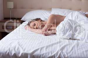 Portrait of pretty satisfied woman lying in bed