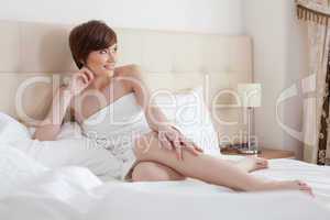Pretty slim woman posing lying in bed, close-up