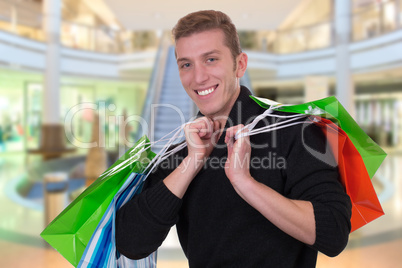 Junger Mann beim Shoppen oder Einkaufen im Geschäft