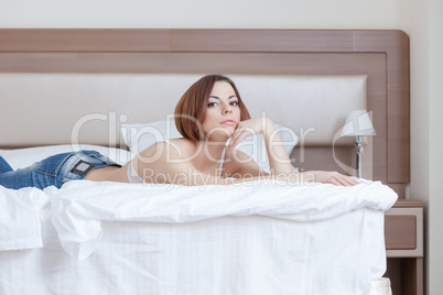 Young attractive model lying on hotel's bed