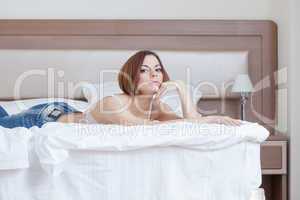 Young attractive model lying on hotel's bed
