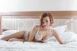 Sensual model posing in erotic lingerie on bed
