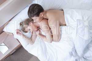 Image of young satisfied lovers lying in bed