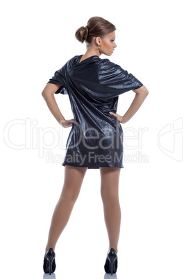 Cute girl in dark blue dress posing back to camera