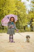 Image of cute little girl walking with dog in park