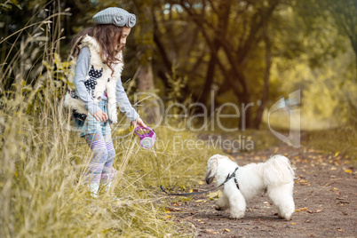 Image of pretty little girl playing with cute dog