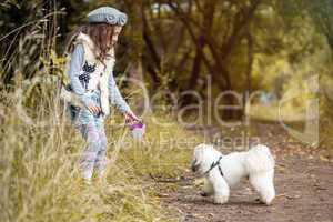 Image of pretty little girl playing with cute dog