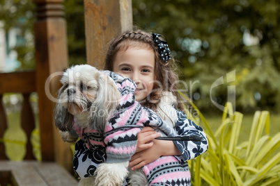 Portrait of adorable little girl hugging pet