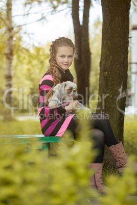 Beautiful little girl holding cute puppy