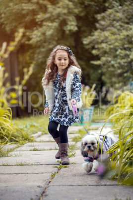 Walk in park - cute girl holding her dog on leash