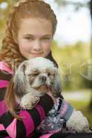 Portrait of beautiful little girl hugging her dog
