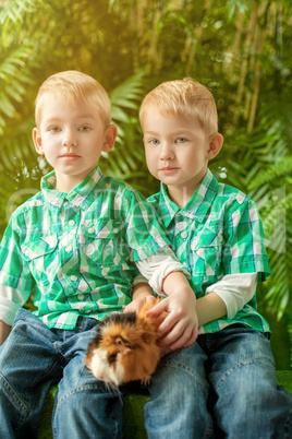 Image of cute young twins posing with guinea pig