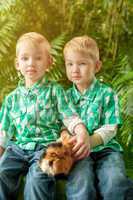 Image of cute young twins posing with guinea pig