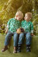 Adorable little twin brothers posing with cavy