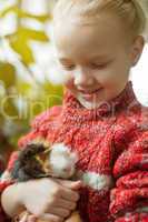 Portrait of smiling little girl looking at cavy