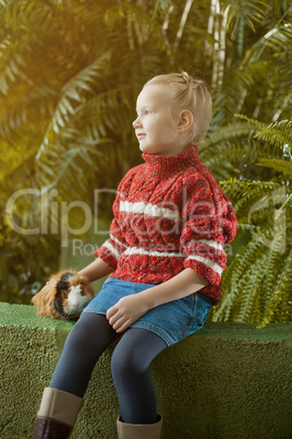 Pretty blond girl posing in park with her pet