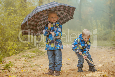 Two young brothers playing in autumn park