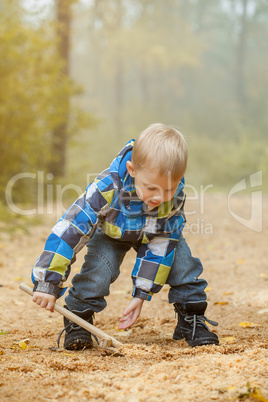 Image of cheerful boy playing in autumn park