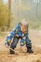 Image of cheerful boy playing in autumn park