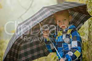 Pretty little boy posing under umbrella, close-up