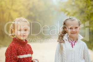 Portrait of pretty young sisters posing in park