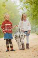 Image of cute young girlfriends walking in park