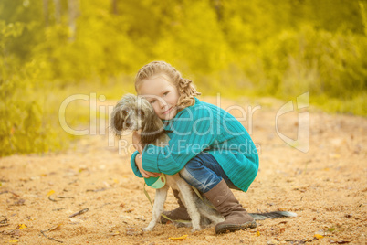 Image of pretty little girl hugging cute dog