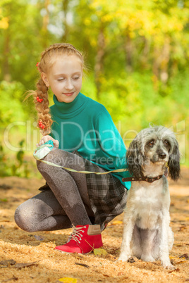 Adorable little girl posing with dog outdoors