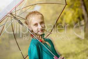 Smiling freckled girl posing with umbrella