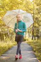 Adorable little girl posing with umbrella in park