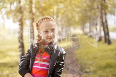 Charming little girl posing in autumn garden