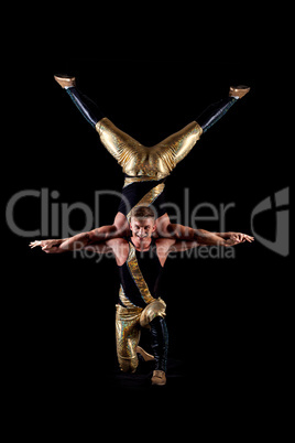 Smiling muscular acrobats isolated on black